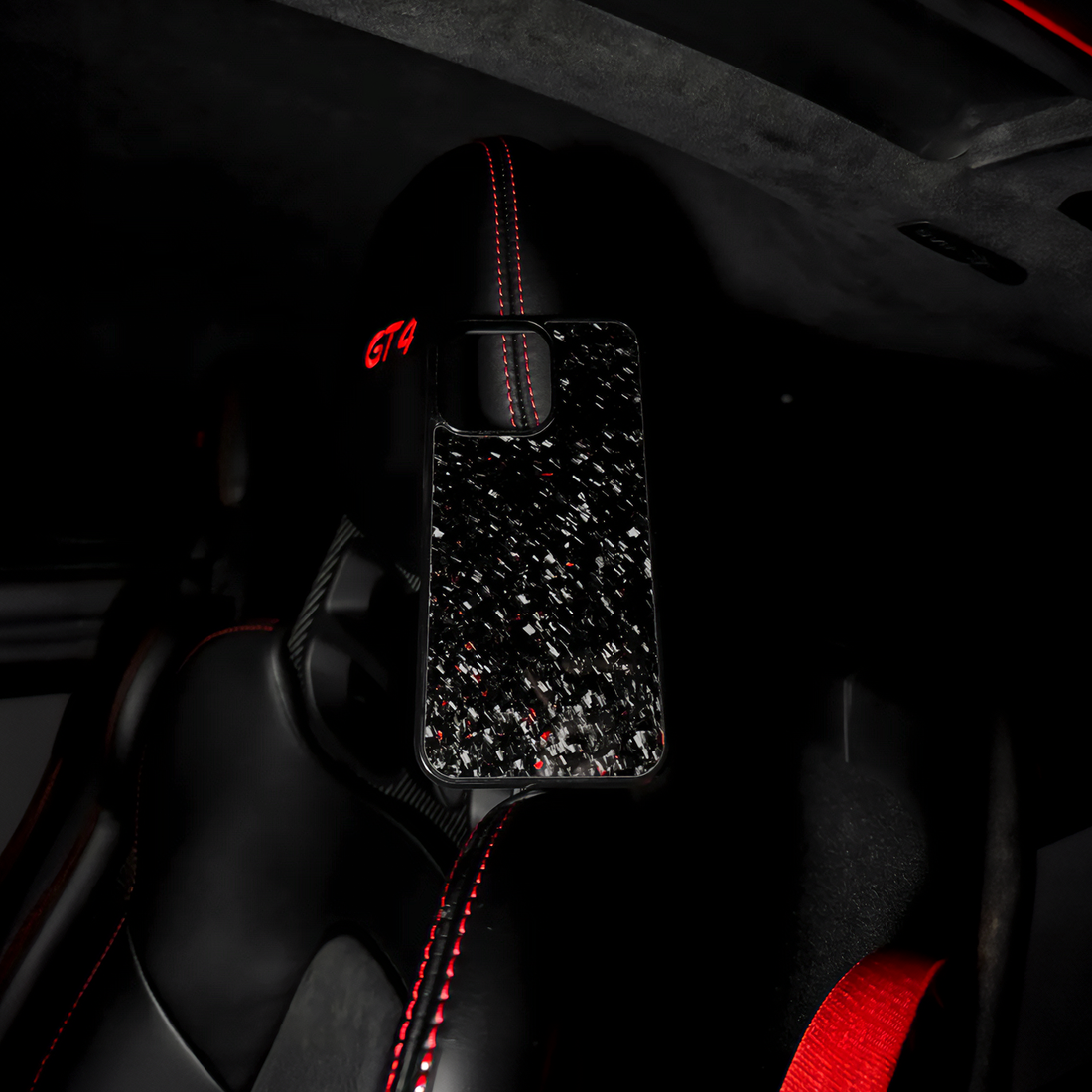Forged red carbon fiber case in black and red sports car interior