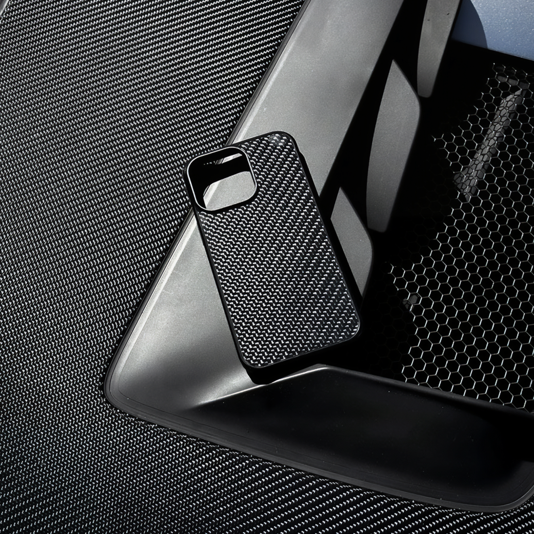 Vensoni Carbon fiber iPhone case on textured surface - overhead view