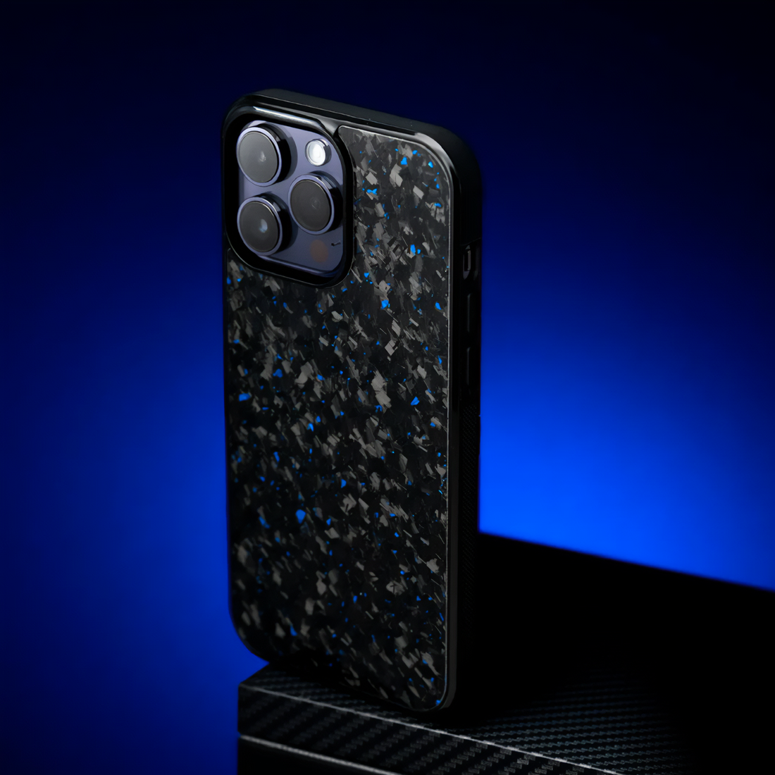 Blue forged carbon iPhone case with dark lighting, luxury studio setup