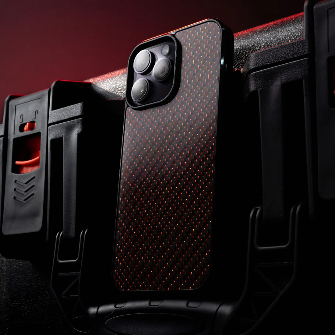 Bold red iPhone case displayed on rugged black toolbox