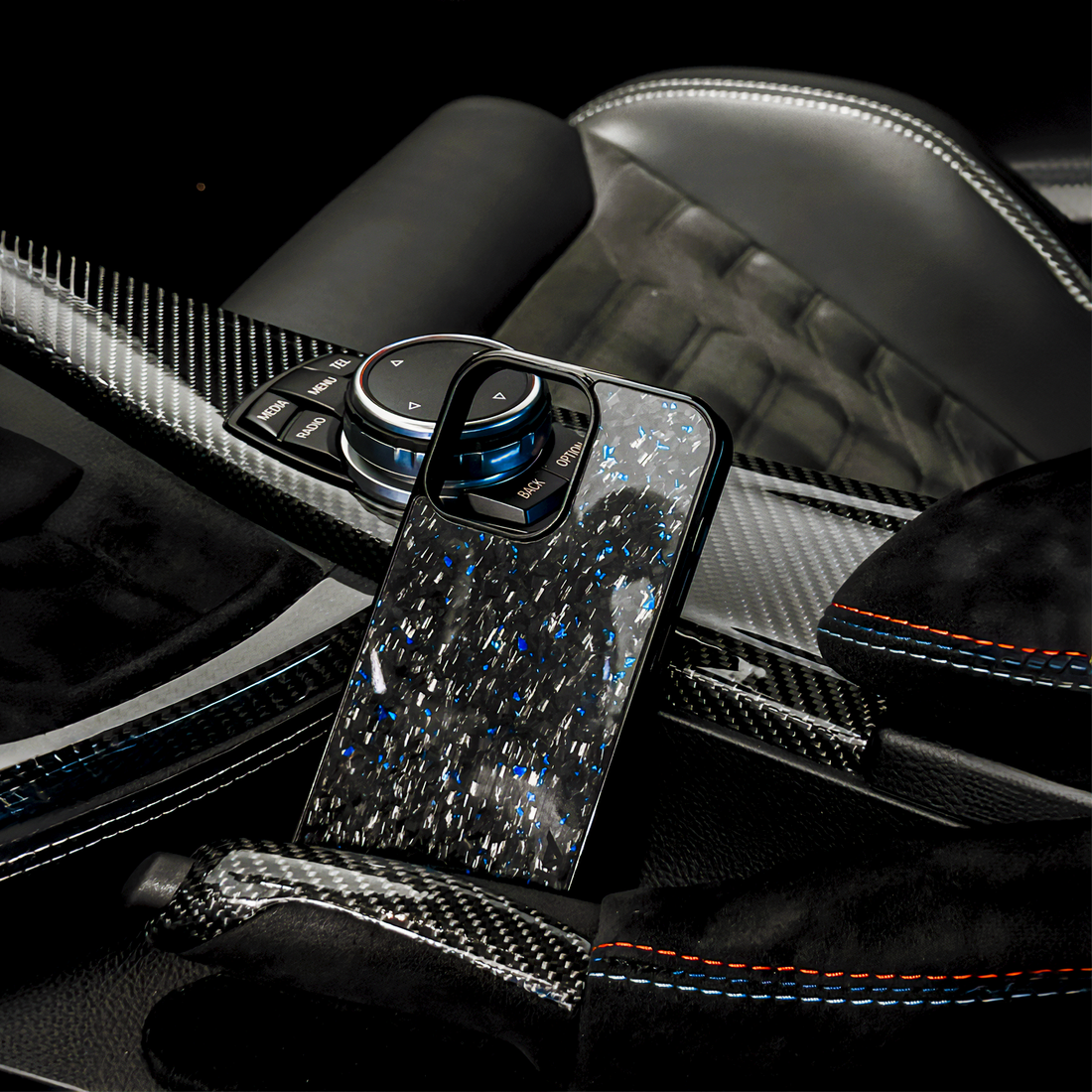 Blue carbon fiber iPhone case placed inside luxury car center console