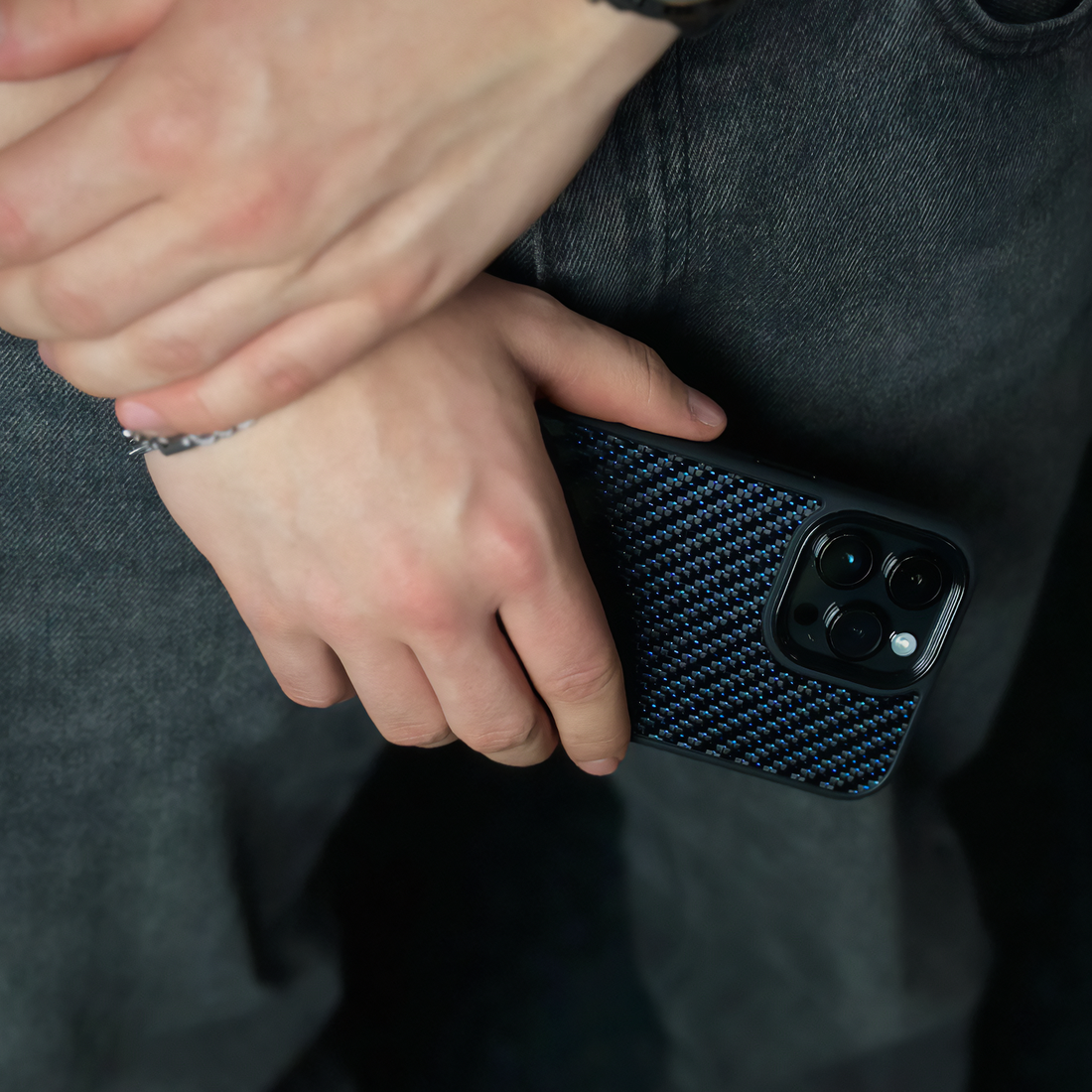 Blue carbon fiber case on iPhone, held in hand for size reference