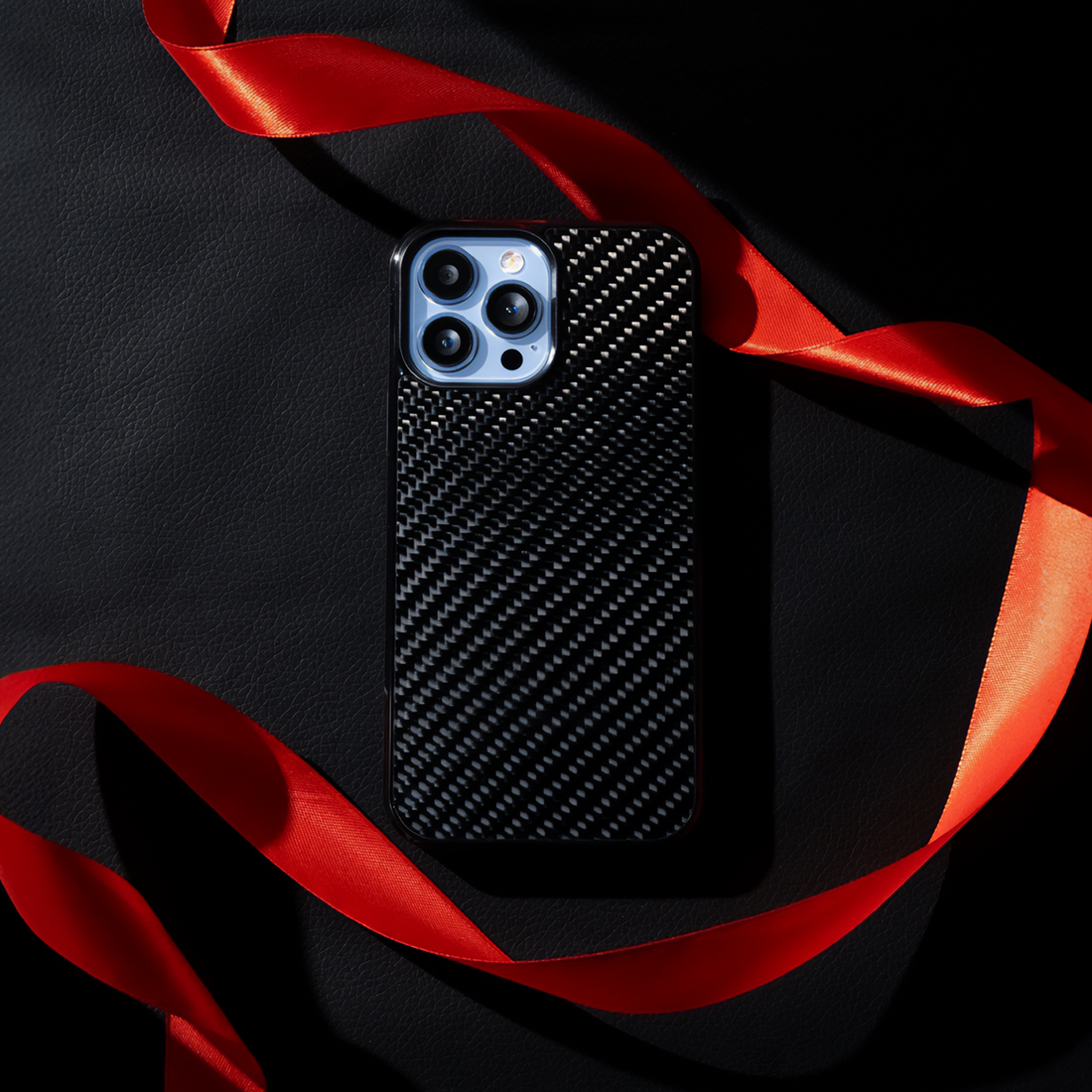 Carbon fiber case with red ribbon - luxury vibe shot