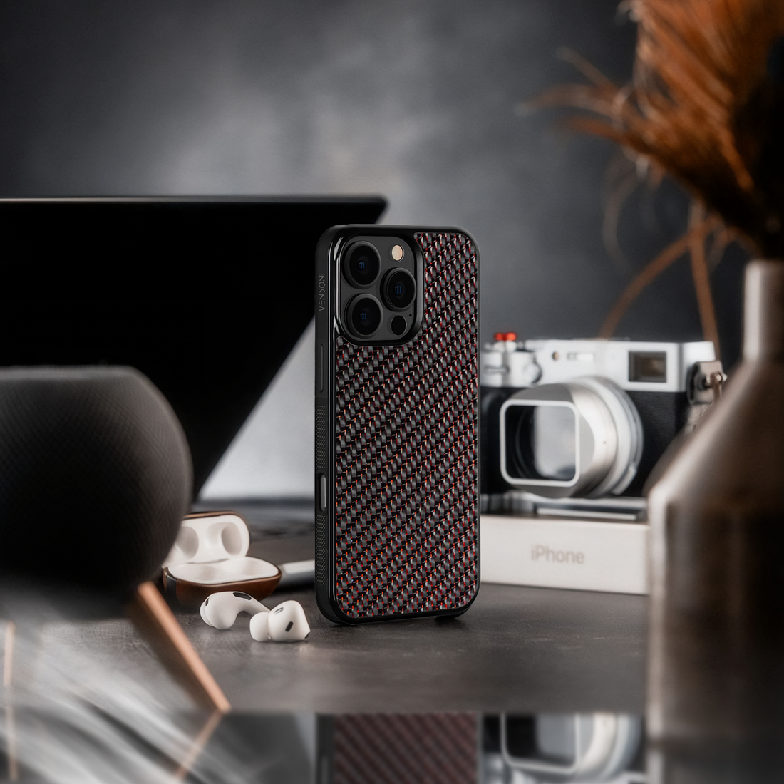 Elegant red iPhone case next to airpod and camera , lifestyle setup
