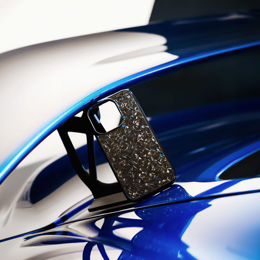 Forged blue carbon fiber iPhone case resting on blue sports car spoiler